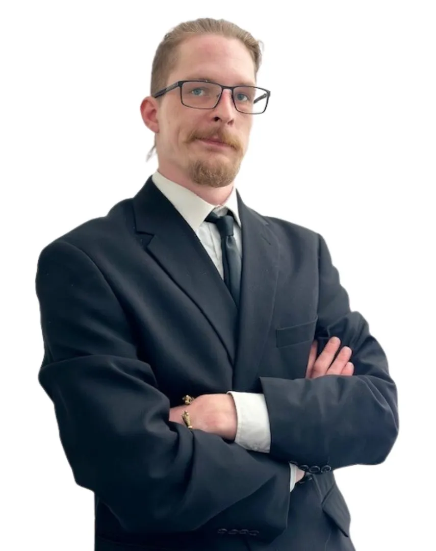 Mann mit Brille und Anzug steht mit verschränkten Armen vor hellem Hintergrund.